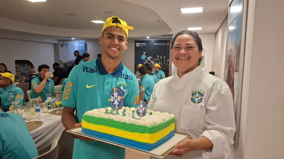 A chefe de cozinha, Cici, entregou o bolo de aniversário para Arthur Gabriel (Foto: CBF)

